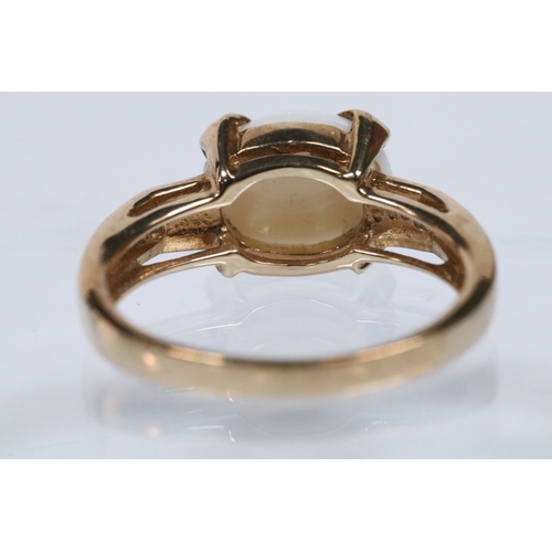 167 - 9ct gold and opal ring set with an oval opal cabochon with two diamond accent stones. Hallmarked Bir... 