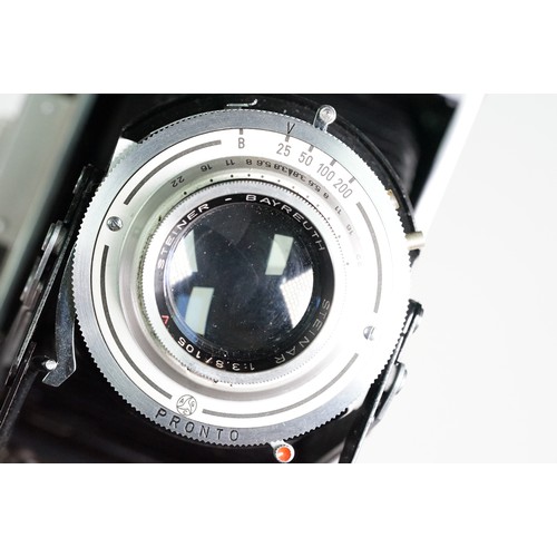 Four cased cameras and accessories to include a folding 'Braun Norca ...