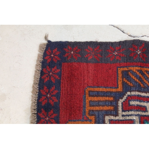 634 - Baluchi rug having a red ground with two geometric medallions to the central panel, 152cm x 88cm