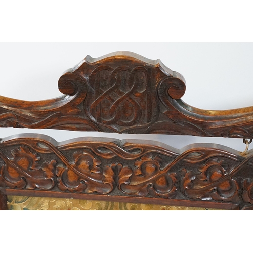 684 - Victorian mahogany framed fire screen, having carved top rail dated 1889 flanked with dogs mask head... 