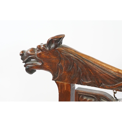 684 - Victorian mahogany framed fire screen, having carved top rail dated 1889 flanked with dogs mask head... 