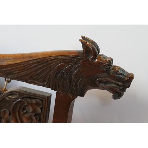 684 - Victorian mahogany framed fire screen, having carved top rail dated 1889 flanked with dogs mask head... 