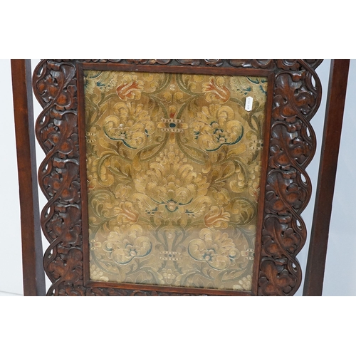 684 - Victorian mahogany framed fire screen, having carved top rail dated 1889 flanked with dogs mask head... 