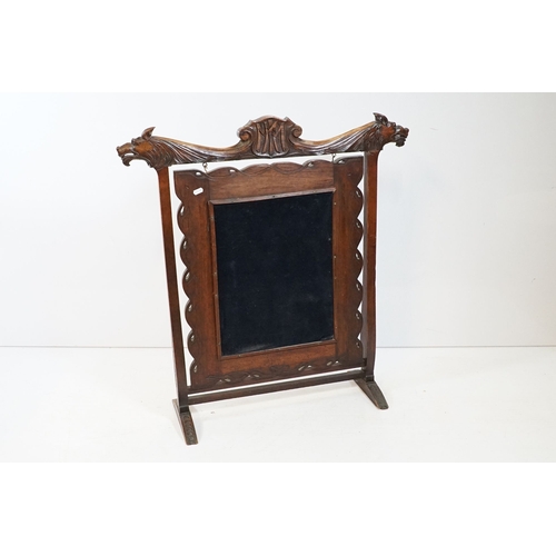 684 - Victorian mahogany framed fire screen, having carved top rail dated 1889 flanked with dogs mask head... 