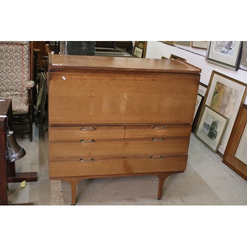 628 - Mid 20th century teak drinks cabinet, having fall front upon three long drawers, raised on square ta... 