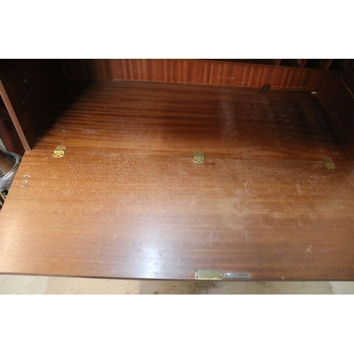 628 - Mid 20th century teak drinks cabinet, having fall front upon three long drawers, raised on square ta... 