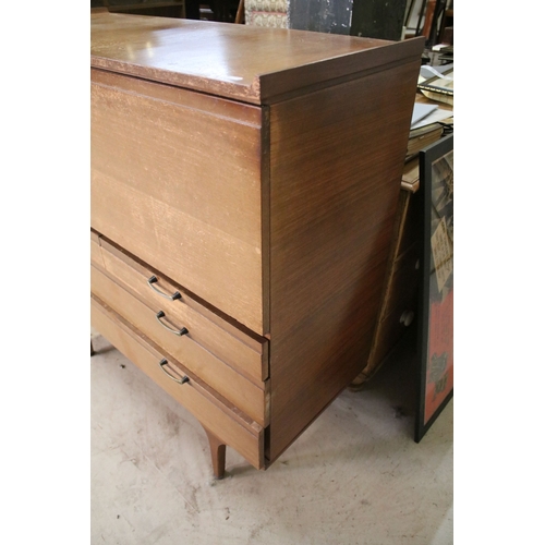 628 - Mid 20th century teak drinks cabinet, having fall front upon three long drawers, raised on square ta... 