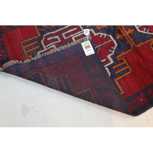 589 - Baluchi rug having a red ground with two geometric medallions to the central panel, 152cm x 88cm