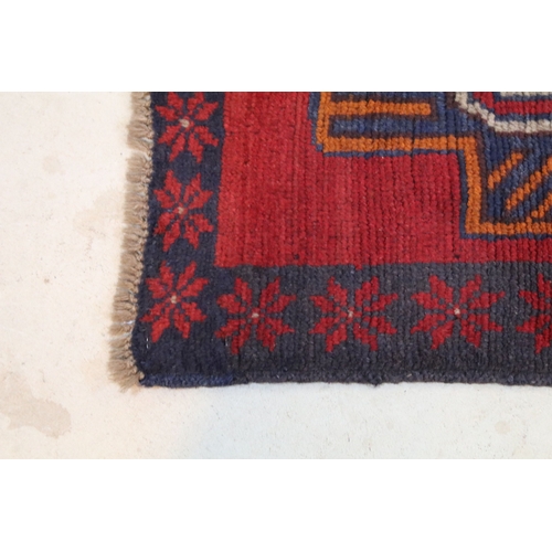 589 - Baluchi rug having a red ground with two geometric medallions to the central panel, 152cm x 88cm