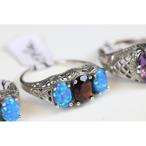 244 - Silver 925 ring with three oval cut blue synthetic opals with filigree surround, together with a sim... 