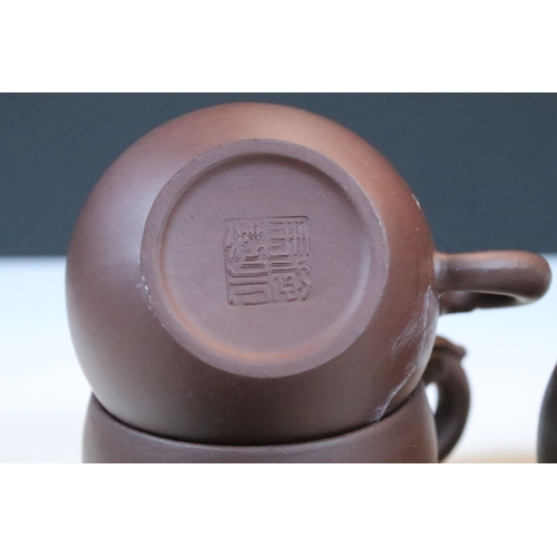 38 - Chinese Yixing terracotta part tea set, the teapot having dragon handle, having four tea cups and si... 
