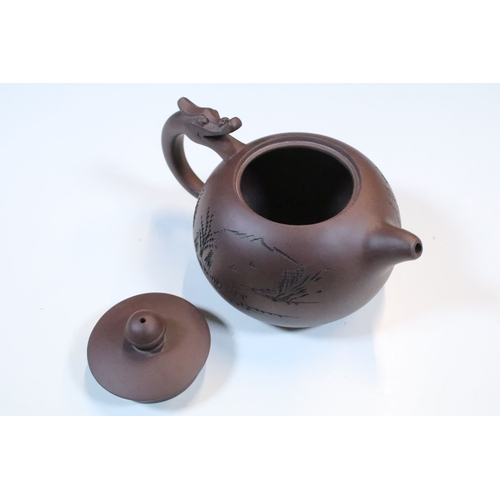 38 - Chinese Yixing terracotta part tea set, the teapot having dragon handle, having four tea cups and si... 