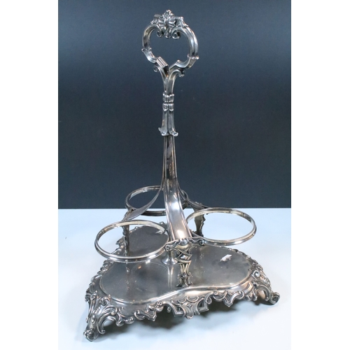 148 - Early 20th century silver plated bottle holder / decanter with ornate handle raised on scroll feet, ... 