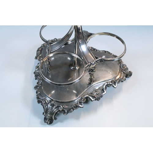 148 - Early 20th century silver plated bottle holder / decanter with ornate handle raised on scroll feet, ... 