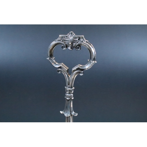 148 - Early 20th century silver plated bottle holder / decanter with ornate handle raised on scroll feet, ... 