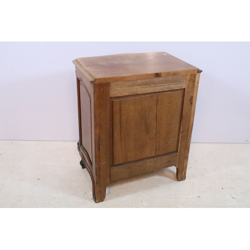 601 - 20th century French-style walnut bedside cabinet, having heavily moulded decoration to door and feet... 