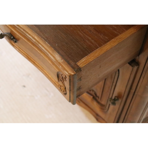 601 - 20th century French-style walnut bedside cabinet, having heavily moulded decoration to door and feet... 