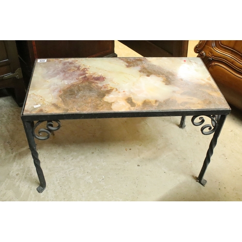 609 - Wrought metal and onyx topped coffee table, having stone inset to the top, raised on twisted legs wi... 