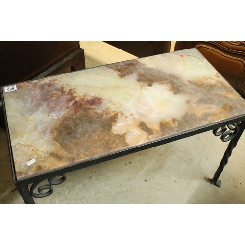 609 - Wrought metal and onyx topped coffee table, having stone inset to the top, raised on twisted legs wi... 