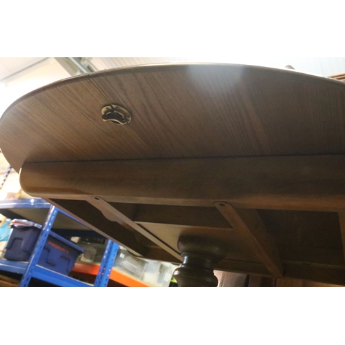 616 - Ercol pedestal extending dining table, having oval top with baluster stem base and swept legs, 110cm... 