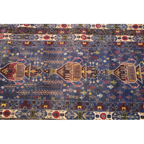 580 - Turkish blue ground rug, having geometric border with colourful accents, 107cm x 206cm