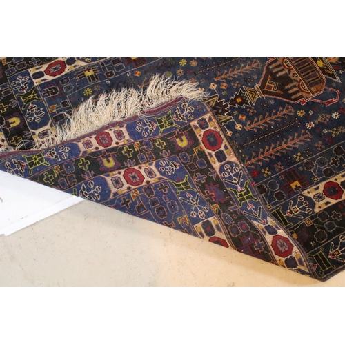 580 - Turkish blue ground rug, having geometric border with colourful accents, 107cm x 206cm