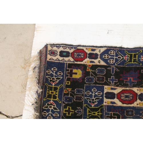 580 - Turkish blue ground rug, having geometric border with colourful accents, 107cm x 206cm