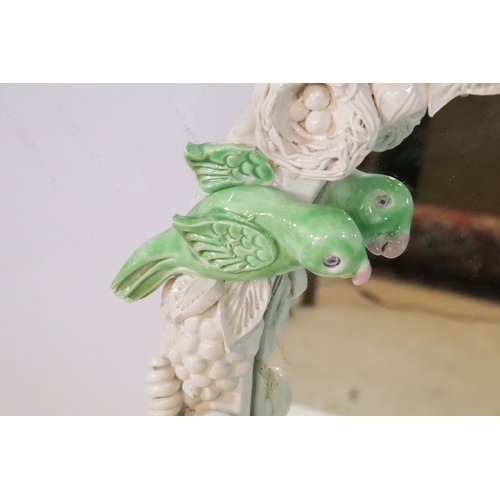 666 - Contemporary pottery framed wall mirror, having birds and foliage to the surround, 60cm x 49cm