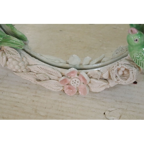 666 - Contemporary pottery framed wall mirror, having birds and foliage to the surround, 60cm x 49cm