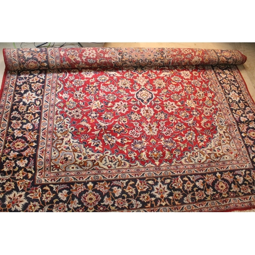 640 - Persian Isfahan rug, of large proportions, of red ground with intertwining swags, within blue border... 