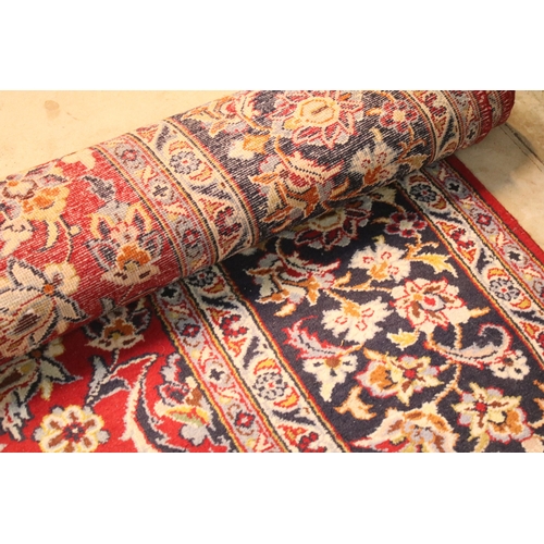 640 - Persian Isfahan rug, of large proportions, of red ground with intertwining swags, within blue border... 