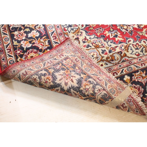 640 - Persian Isfahan rug, of large proportions, of red ground with intertwining swags, within blue border... 