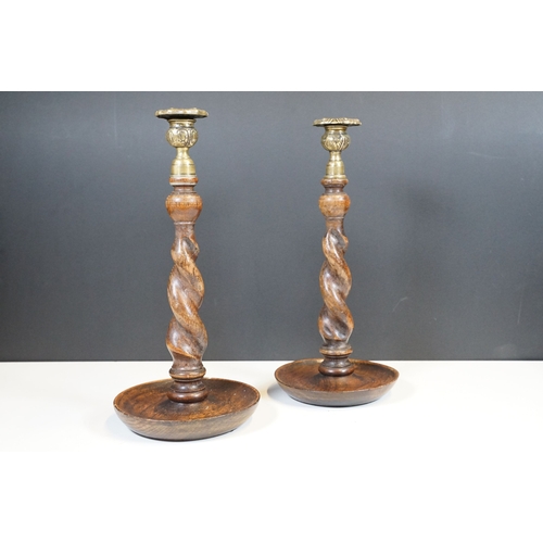124 - Pair of early 20th century turned oak barley twist candle sticks with circular bases and ornate bras... 
