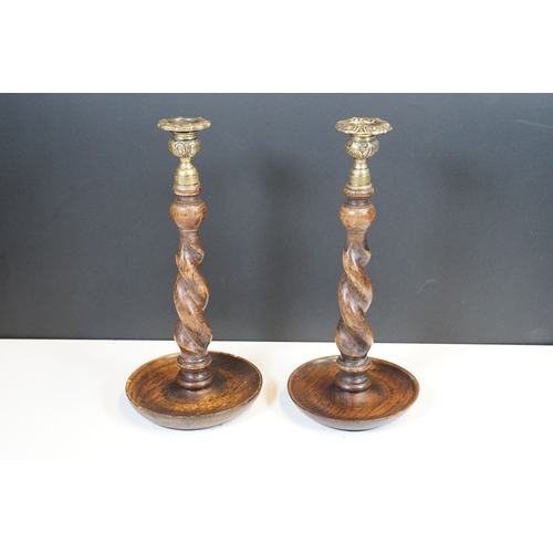 124 - Pair of early 20th century turned oak barley twist candle sticks with circular bases and ornate bras... 