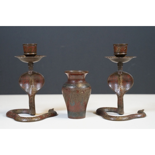 138 - Pair of coiled cobra candlesticks, H 15cm together with a small Indian brass vase, H 9cm (3)