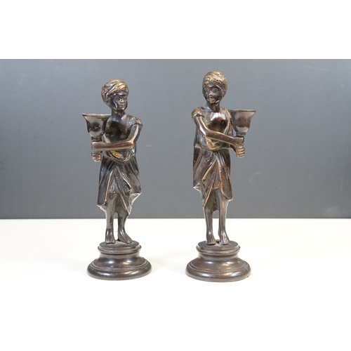 144 - Pair of Indian bronze candelabra candle holders depicting figures holding torches raised on circular... 