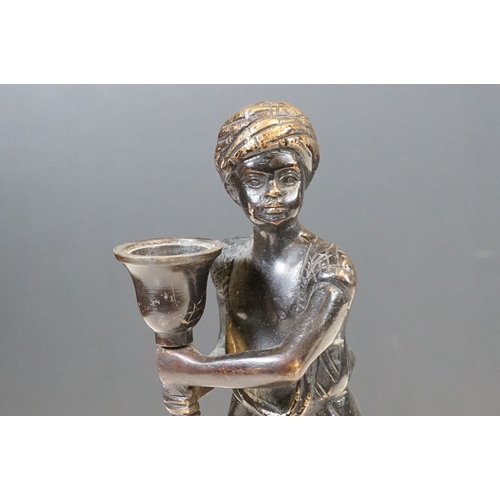 144 - Pair of Indian bronze candelabra candle holders depicting figures holding torches raised on circular... 