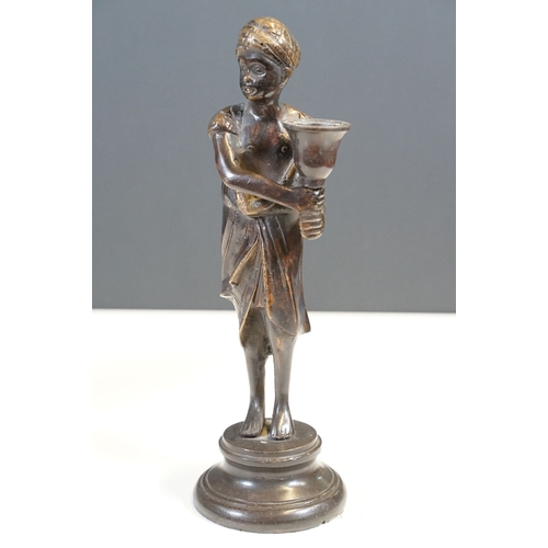 144 - Pair of Indian bronze candelabra candle holders depicting figures holding torches raised on circular... 