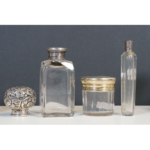 333 - A collection of vanity jars and bottles to include silver topped examples.