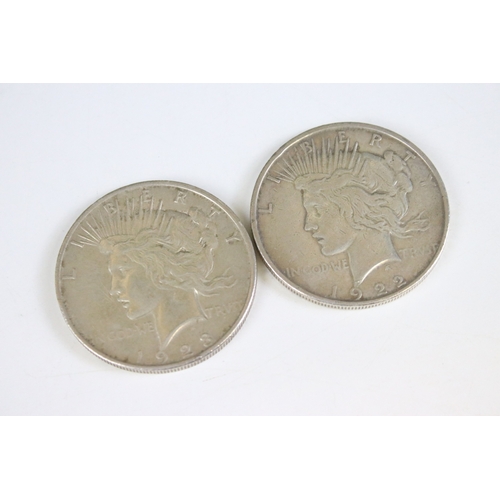425 - A small collection of coins to include two United States of America silver peace dollars.
