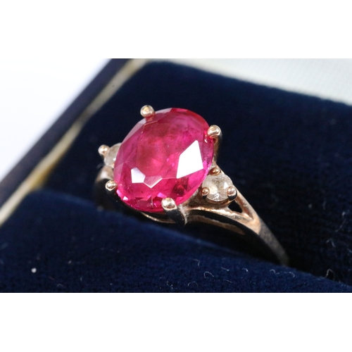191 - 10ct gold, synthetic ruby and white stone ring. The ring being set with an oval cut synthetic ruby f... 
