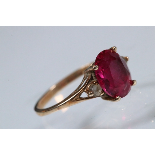 191 - 10ct gold, synthetic ruby and white stone ring. The ring being set with an oval cut synthetic ruby f... 