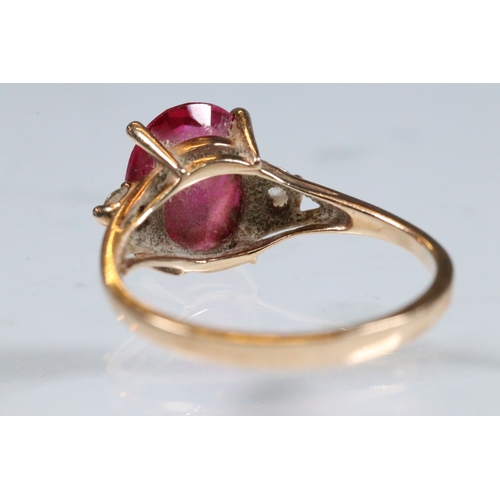 191 - 10ct gold, synthetic ruby and white stone ring. The ring being set with an oval cut synthetic ruby f... 
