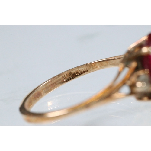 191 - 10ct gold, synthetic ruby and white stone ring. The ring being set with an oval cut synthetic ruby f... 