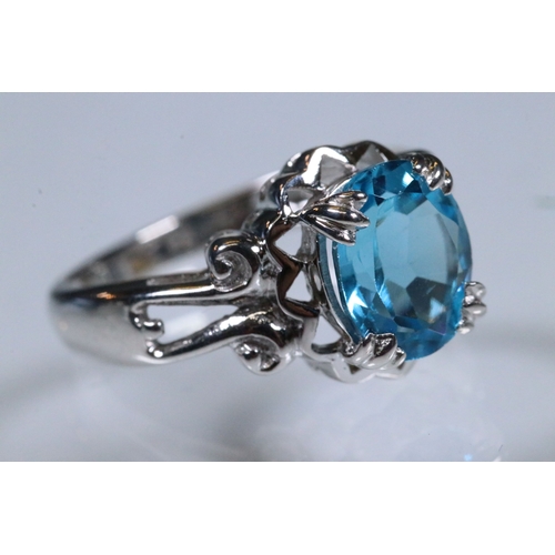 234 - 9ct white gold and blue topaz dress ring being set with an oval mixed cut topaz with pierced and scr... 