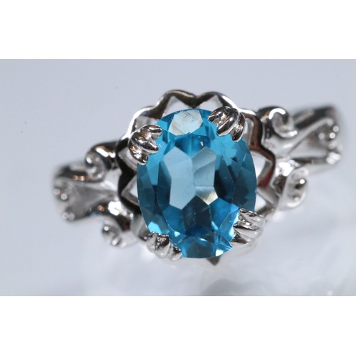 234 - 9ct white gold and blue topaz dress ring being set with an oval mixed cut topaz with pierced and scr... 