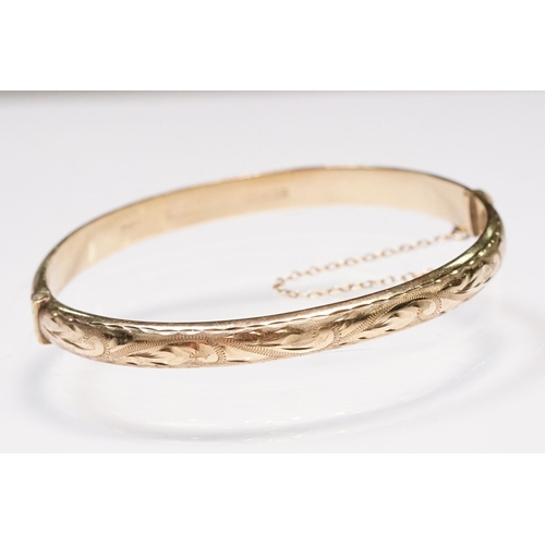 186 - 9ct gold bangle bracelet with engraved exterior and hinged opening. Hallmarked Birmingham 1990. Meas... 