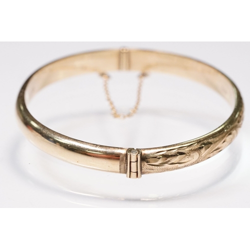 186 - 9ct gold bangle bracelet with engraved exterior and hinged opening. Hallmarked Birmingham 1990. Meas... 