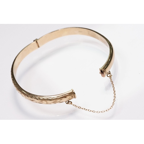186 - 9ct gold bangle bracelet with engraved exterior and hinged opening. Hallmarked Birmingham 1990. Meas... 