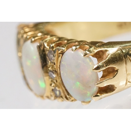 24 - 18ct gold, opal and diamond ring. The ring being set with three oval opal cabochons with six diamond... 